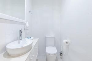 彩虹海滩黛比之家酒店的白色的浴室设有水槽和卫生间。