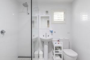 彩虹海滩黛比之家酒店的白色的浴室设有卫生间和水槽。