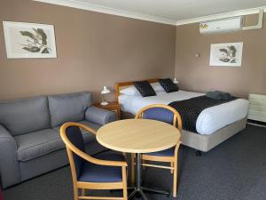 奥伯伦高地汽车旅馆的酒店客房配有床、桌子和沙发。