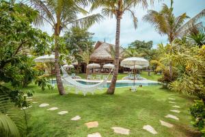 乌鲁瓦图姆玛热带住宿加早餐旅馆的一个带吊床和游泳池的度假庭院