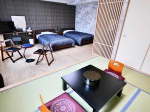 小谷村Apprising hotels GranJam Tsugaike的配有一张床和一张桌子及椅子的房间