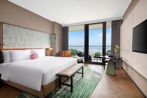 苏州苏州阳澄半岛英迪格酒店的一间卧室设有一张大床和一个大窗户