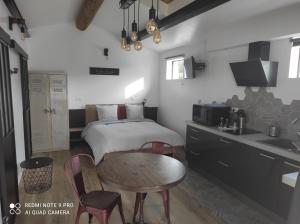 谢瓦布朗克L'atelier de Guytou et Spa的一间卧室配有一张床铺和一张桌子,还设有一间厨房