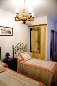 CózarCasa Rural Morada Maragata的一间卧室配有两张床和吊灯。