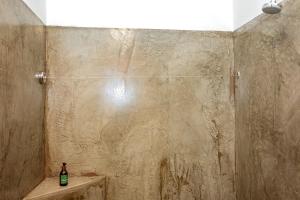 DuwisibAt Kronenhof Lodge的带淋浴的浴室,配有1瓶位于水槽的瓶装水