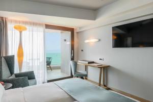 罗希姆诺BIO BEACH Boutique Hotel - Adults Only的酒店客房设有一张床,享有海景。