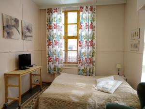KoveroKoveron Majatalo的一间卧室配有一张床、一张书桌和一个窗户。
