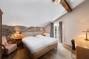 La Gleize拉赖因阿斯特里德酒店的卧室配有一张白色的大床和一张桌子