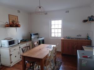 科尔斯伯格Yardley Cottage的厨房配有木桌和微波炉