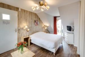 埃皮尼亚克Les Ormes Domaine et Resort的卧室配有白色的床和电视