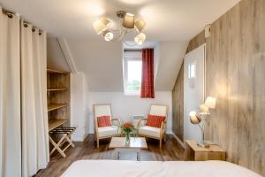 埃皮尼亚克Les Ormes Domaine et Resort的一间卧室配有一张床、两把椅子和一个窗户