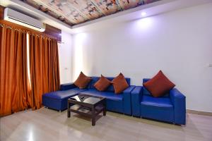 果阿旧城FabHotel Ocean View Apartment, Dabolim的客房内的蓝色沙发上配有枕头