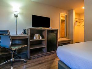 切罗基切诺基经济酒店的酒店客房配有一张床、一把椅子和一台电视。