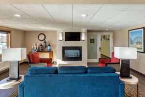 Jackson杰克逊舒适套房酒店 - 西区的客厅设有蓝色的沙发和壁炉