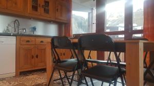 La Plagne TarentaisePlagne centre -Pied de pistes的厨房配有木桌和三把椅子