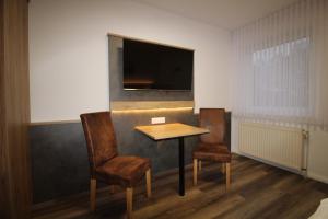 帕彭堡司徒贝酒店的配有桌子和两把椅子以及电视的房间