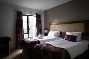 阿德格罗夫Ballyrobin Hotel的酒店客房设有两张床和窗户。