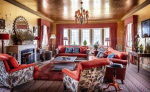 泰恩The Glenmorangie House的客厅配有红色家具和壁炉