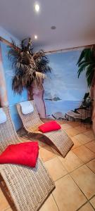 阿恩施塔特帕克斯酒店的一间设有藤椅和棕榈树壁画的房间