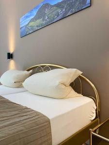 巴特洪内夫Weingut Pieper - Vinothek & Hotel am Drachenfels的一张带白色枕头的床和一张墙上的照片