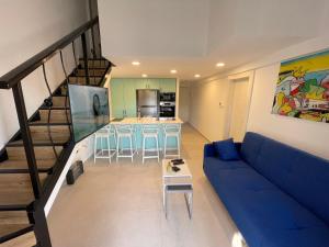 埃拉特Top Royal Eilat רויאל פארק的一间带蓝色沙发的客厅和一间厨房