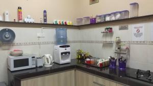 普崇Cosy P6 Homestay的厨房配有微波炉和台面上的咖啡壶