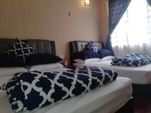 普崇Cosy P6 Homestay的配有两张床铺的蓝色和白色枕头