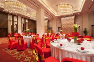 北京北京西单美爵酒店的宴会厅配有白色桌子和红色椅子