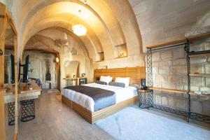 格雷梅阿加特洞穴酒店的一间带一张大床的卧室,位于带天花板的房间内