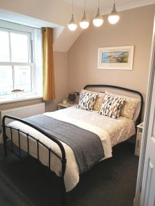 滕比Ivy Bank Guest House, Tenby的卧室配有带枕头的床铺和窗户。