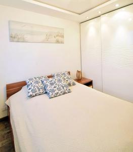 格丁尼亚Avis Apartments - Gdynia Władyslawa 32的卧室配有白色的床和枕头。