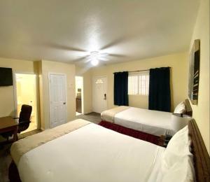 沙漠温泉欧罗巴套房酒店的酒店客房配有两张床和吊扇。