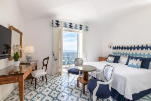 阿马尔菲圣塔卡特林纳酒店的配有一张床、一张书桌和一扇窗户的酒店客房