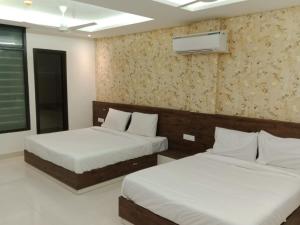 MohaliHOTEL GOLDEN LEAF的卧室配有两张床,墙上配有空调