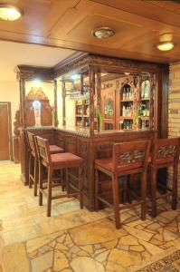Bieruń Nowy阿德里亚旅馆的一间酒吧,配有木制家具和椅子
