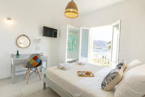 帕罗奇亚阿克罗蒂里酒店的一间卧室配有一张床、一张书桌和一个窗户。