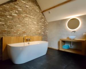克勒伊斯贝尔亨Nachtegael Hoekhuis, knusse woning met prachtig vergezicht的浴室配有大型白色浴缸和水槽