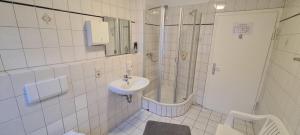 斯图加特拉姆酒店的白色的浴室设有水槽和淋浴。