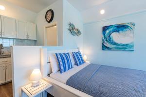 拿骚Sunshine Studio at Viking Hill - Love Beach的卧室配有一张床,墙上挂着一个钟