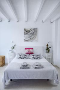 亚伊萨Ocra Apartment的白色卧室配有一张带两个枕头的大床