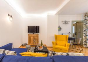 科尔马Thann Colmar - 1 chambre - 5 pers - Parking的客厅配有蓝色的沙发和黄色的椅子
