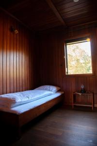 瓦森贝格Gitstapper Hof natuurhuis的木制客房的一张床位,设有窗户
