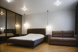 赫梅利尼茨基Сучасний Люкс的一间卧室配有一张床和一把椅子