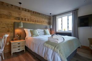 赛伦塞斯特Wild Thyme & Honey的一间卧室设有一张带木墙的大床