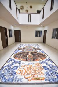 多洛雷斯-伊达尔戈HOTEL MI HERMOSO DOLORES的客房铺有瓷砖地板,配有绘画作品
