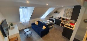 多维尔Le Deauvillais - Appartement Plein Centre - 4 pers - 2 mn plage - Idéal Famille的一间带蓝色沙发的客厅和一间厨房