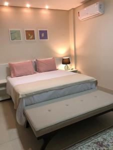 阿拉瓜伊纳Baruch Hotel的卧室配有一张带粉红色枕头的大床