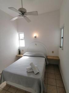 科利马Htl & Suites Neruda, ubicación, limpieza, facturamos的白色卧室配有一张带吊扇的床