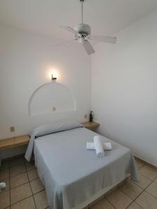 科利马Htl & Suites Neruda, ubicación, limpieza, facturamos的一间卧室配有一张带吊扇的床