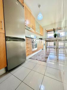 布拉加University of Minho- INL Campus Gualtar Apartment 2的厨房配有不锈钢冰箱和桌子
